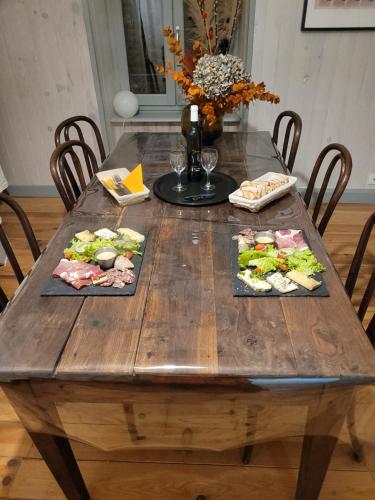 a wooden table with three plates of food on it at Chambres d'hôtes du Bistrot d'ici in Saint-Saturnin