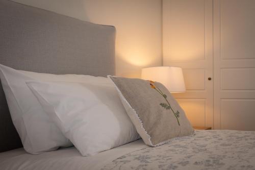 a bed with white pillows and a pillow on it at Beach villa Aetos kaminaki Nissaki in Nisakion