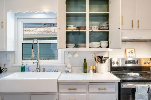 uma cozinha com armários brancos e um lavatório em Brygger Cottage BY Betterstay em Seattle