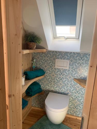 une petite salle de bain avec toilettes et fenêtre dans l'établissement Komfort Maisonettewohnung, à Zirndorf