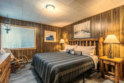um quarto com uma cama com paredes de madeira e uma janela em The Yellow Cabin BY Betterstay em Packwood