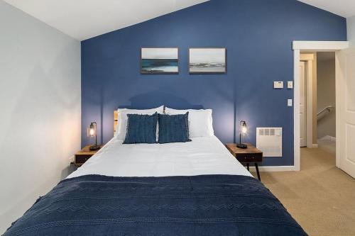 a blue bedroom with a large bed with blue walls at Aurora Abode BY Betterstay in Seattle
