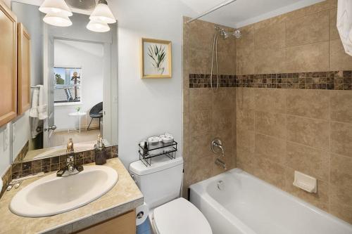 a bathroom with a sink and a toilet and a tub at Aurora Abode BY Betterstay in Seattle