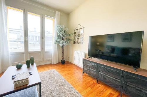 un salon avec une grande télévision à écran plat dans l'établissement #GF The Grenoble Beret next to the train station et GEM, à Grenoble