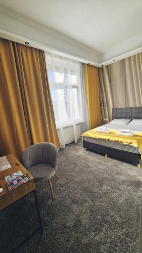 a bedroom with a bed and a chair and a table at B&B President in Zagreb