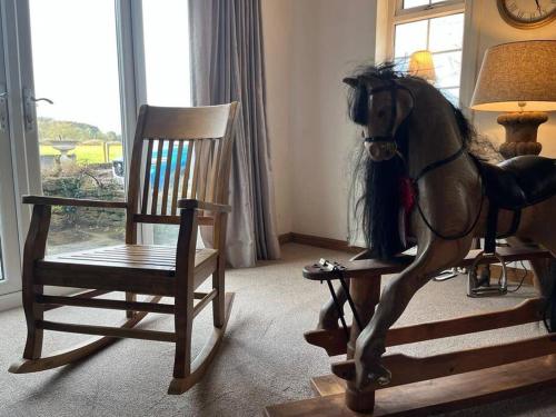 una estatua de un caballo de pie junto a una mecedora en Brownhills, en Eaton