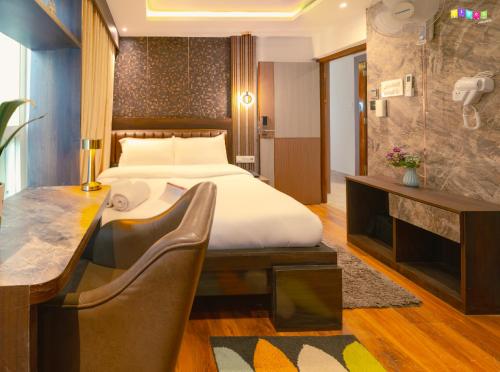 a hotel room with a bed and a desk and a table at Flock Kathmandu in Kathmandu