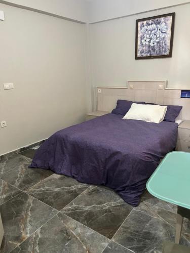 Zerya suites في إسطنبول: غرفة نوم مع سرير مع ملاءات أرجوانية وطاولة