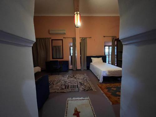 a view of a bedroom with a bed and a living room at Kasbah Tifoultoute in Ouarzazate