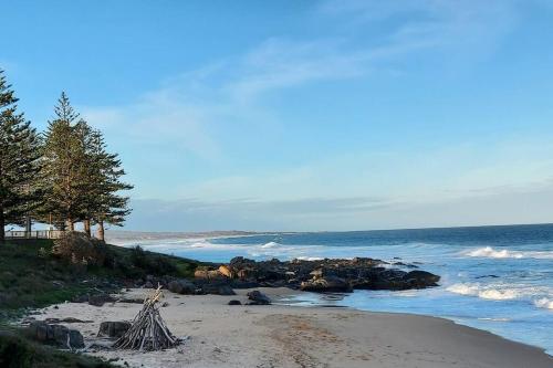 a beach with a bunch of rocks and the ocean at Bondi Breeze @ Tuross Head in Tuross Heads