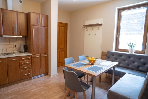 a kitchen and dining room with a table and chairs at Apartamenty Sadowy in Wisła