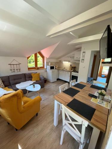 a living room with a table and a couch at Penzión Pod Guglom in Mlynky 