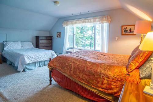 1 dormitorio con 2 camas y ventana en Smith Family Cottages- Lake House, en Indian River