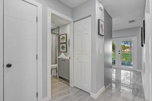 a hallway with white walls and a white door at Hallandale Collection - Renovated Professional Design & Lake View in Ro-Len Lake Gardens