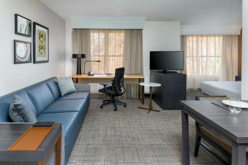 Habitación de hotel con sofá, cama y escritorio. en Residence Inn Greenville-Spartanburg Airport en Greenville