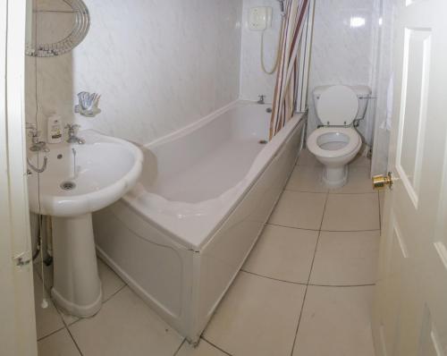 a bathroom with a tub and a toilet and a sink at Cozy Old Town Apartment in Nicolson Street in Edinburgh