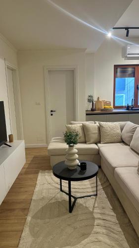 a living room with a white couch and a table at Gjirokastra Design Apartments in Gjirokastër