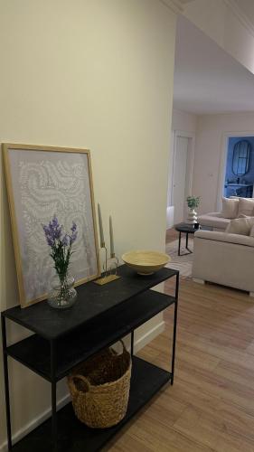 a living room with a table with flowers on it at Gjirokastra Design Apartments in Gjirokastër