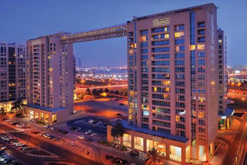 ein hohes Gebäude mit einem Kran darüber in der Unterkunft Marriott Executive Apartments Dubai Creek in Dubai