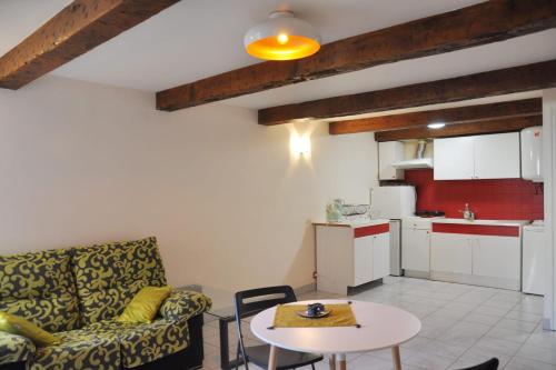 un salon avec un canapé et une table et une cuisine dans l'établissement Cozy 1-Bedroom Apartment near Vieux-Port, à Marseille