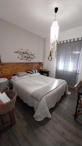 a bedroom with a large bed and a chandelier at VILLA VILLACOLLE in Procchio