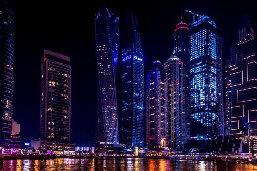 a group of tall buildings in a city at night at Best Hostel near Sharaf DG metro in Dubai