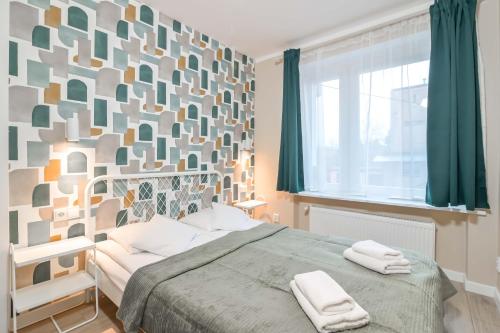 グディニャにあるWilla LTC Apartments Orłowoのベッドルーム1室(ベッド1台、タオル2枚付)