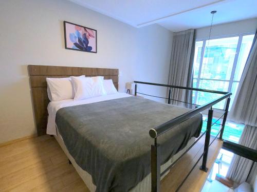 ein Schlafzimmer mit einem Bett und einem großen Fenster in der Unterkunft Maximus Luxury NYC Berrini III in São Paulo