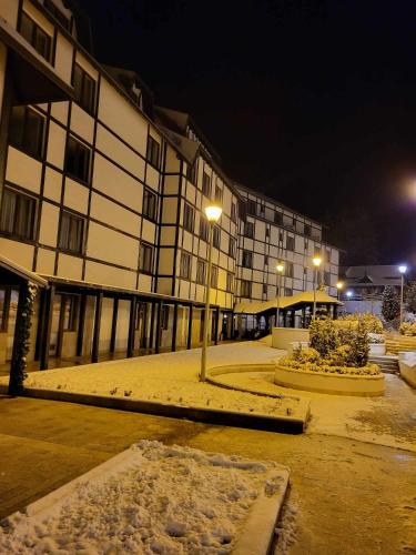 a building with snow in front of it at night at Apartman Ema, Blizu Gondole Brzeće - Kopaonik in Brzeće
