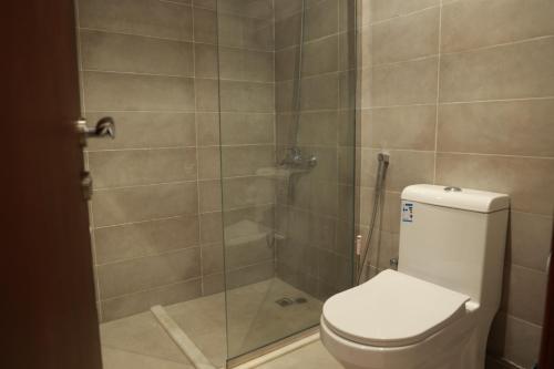 a bathroom with a toilet and a glass shower at فندق سيف بلص من سما in Makkah