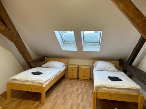 2 camas en un ático con 2 ventanas en Apartmány Zahradní, en Františkovy Lázně