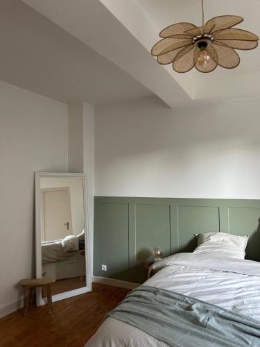 - une chambre avec un lit, un ventilateur de plafond et un miroir dans l'établissement Spacieux appartement au coeur du centre historique de Dinan, à Dinan