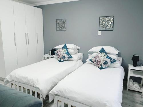 two beds in a room with blue walls at Blissful Stays in Richards Bay
