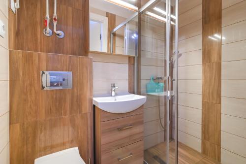 W łazience znajduje się toaleta, umywalka i prysznic. w obiekcie Willa LTC Apartments Orłowo w mieście Gdynia
