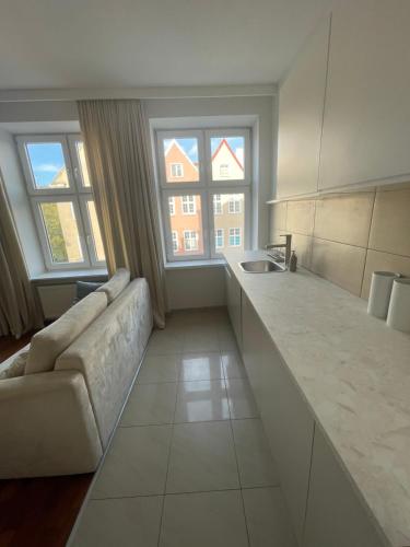 sala de estar con sofá y cocina con 2 ventanas en Apartament w centrum Gdańska en Gdansk