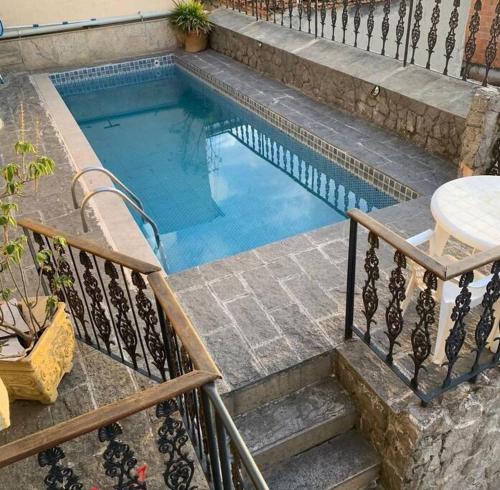 a swimming pool with stairs and a table next to it at Casa Com Piscina Porto Maravilha in Rio de Janeiro
