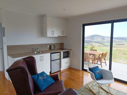 a kitchen with a couch and a chair and a table at Fingerpost Hill Farm Stay in Campania