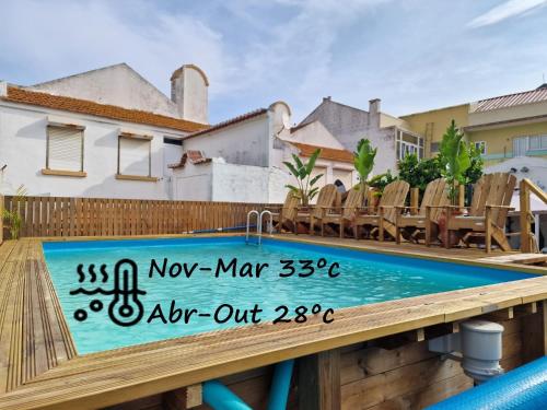 a swimming pool with chairs and a sign on a deck at Vila Maria Apartments by Host-Point in Costa da Caparica