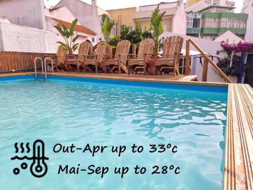 a swimming pool with chairs and a sign next to it at Vila Maria Apartments by Host-Point in Costa da Caparica