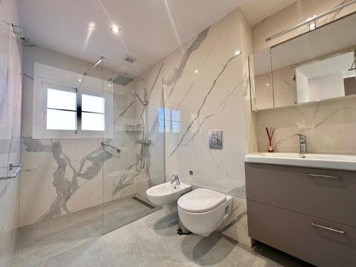 een badkamer met een toilet, een wastafel en een douche bij Sunset Apartment 3 & Heated pool in Los Cristianos