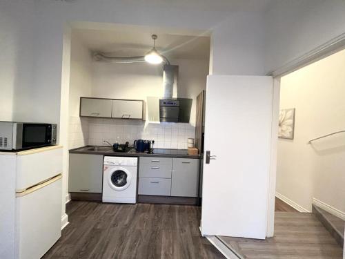a kitchen with a stove and a washer and dryer at Yeovil Apartments in Yeovil