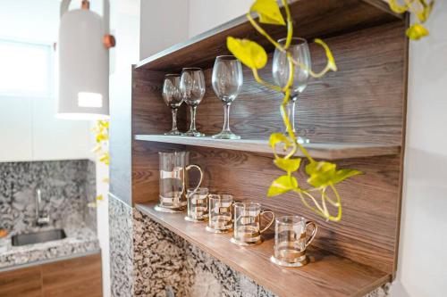 a row of wine glasses on a shelf in a kitchen at Luxury Apartment estilo Berlin, de estreno in Guayaquil