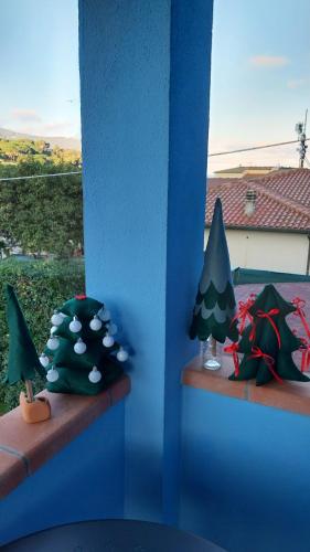 two miniature christmas trees are sitting on a shelf at VILLA VILLACOLLE in Procchio