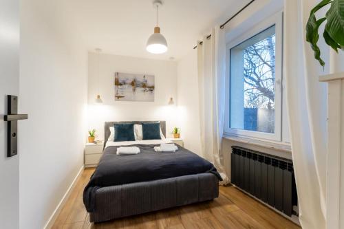 ein Schlafzimmer mit einem großen Bett und einem Fenster in der Unterkunft Apartament Fika - klimatyczny w centrum miasta by SpaceApart in Jelenia Góra