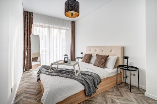 a bedroom with a bed with a table on it at cohost I New Bastėja Life Apartments w-Garage Prkg & Self Check-in in Vilnius