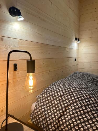 Habitación con cama en una pared de madera. en Metabief- Front de piste en Métabief