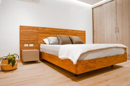 a bedroom with a large bed with a wooden headboard at Luxury Apartment estilo Berlin, de estreno in Guayaquil