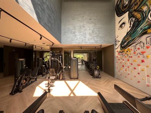 um ginásio com equipamento cardiovascular e uma parede com uma pintura em Iconyc Charlie Hotel São Paulo - Soft Opening em São Paulo