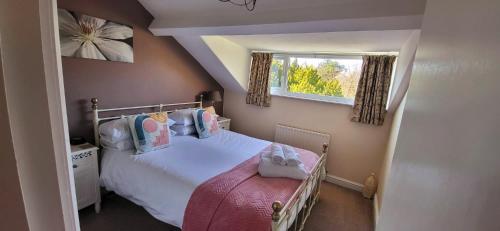 a small bedroom with a bed and a window at Ferndene Guest House in Keswick