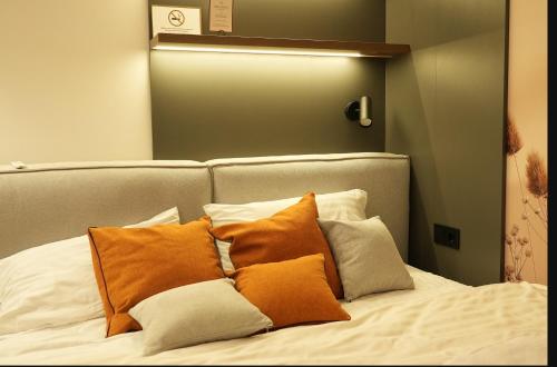a bed with orange and white pillows on it at Luxury apartment with jacuzzi Pechersk Plaza in Kyiv